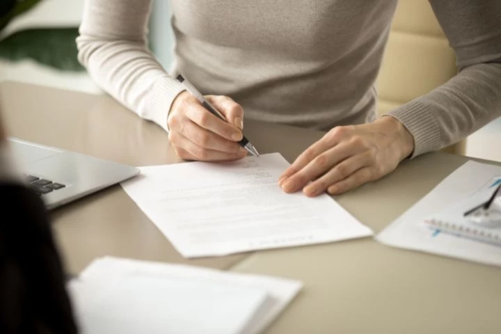 Femme qui signe des documents légaux